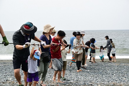 大磯海岸で地引網の綱を引く親子