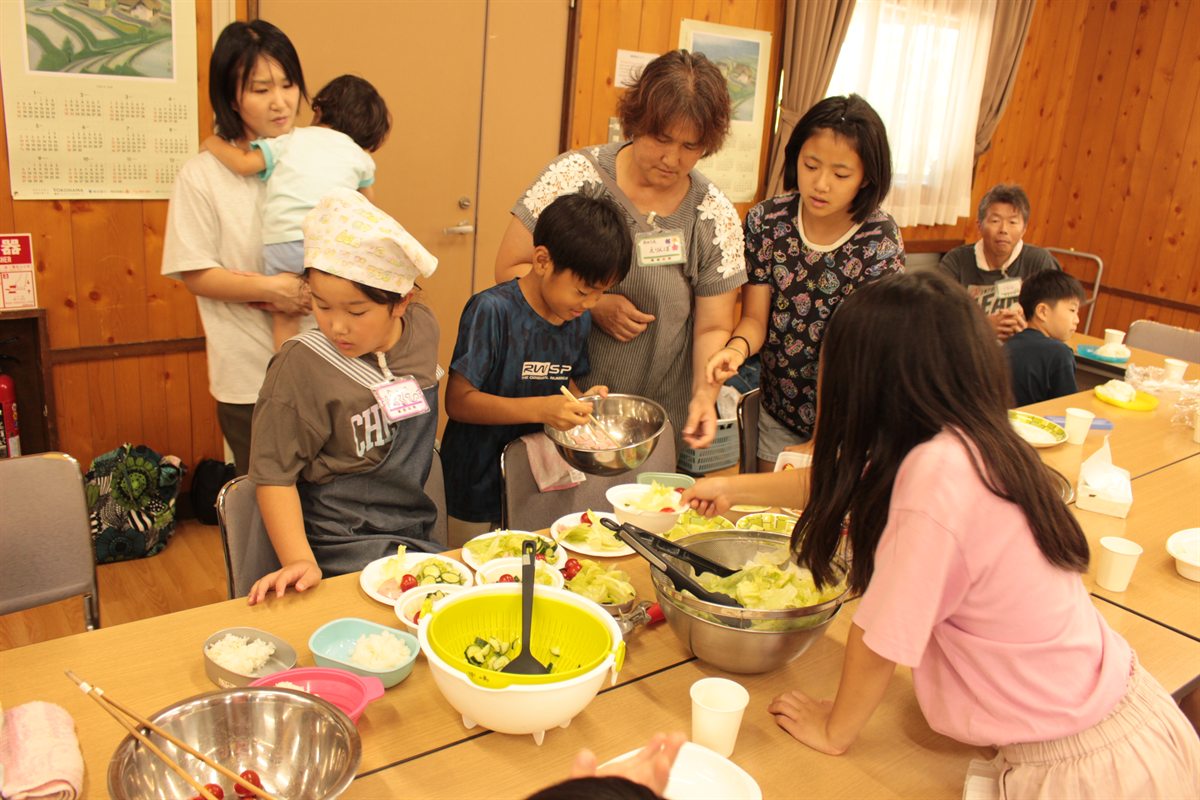 みのり館の広間でサラダを盛りつける子どもたち