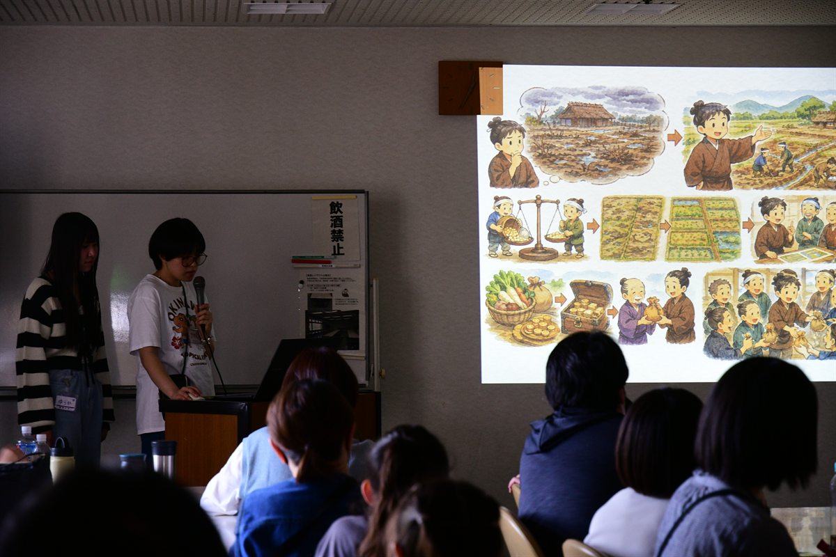 尊徳記念館の広間で、おにぎりを食べる参加者たち